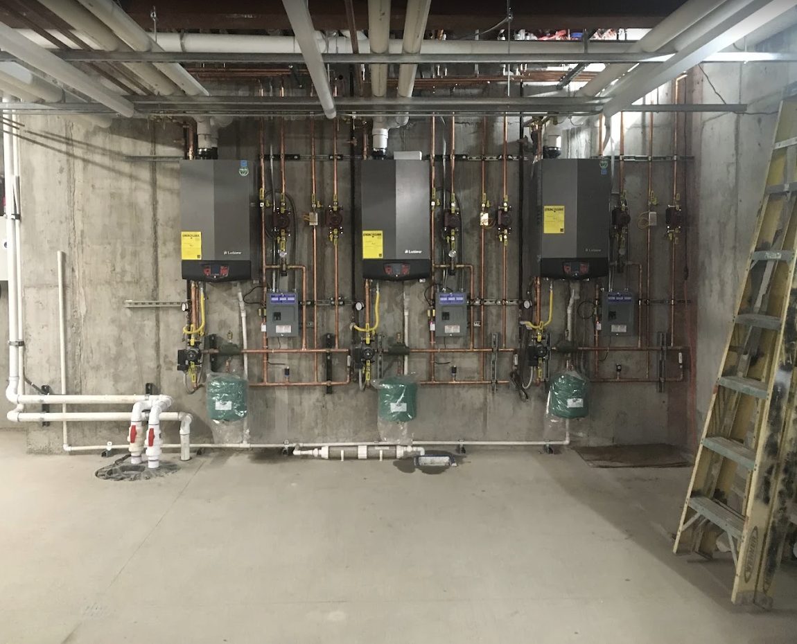 A bank of three high-efficiency boilers piped in copper with gas lines, installed by Top Tier