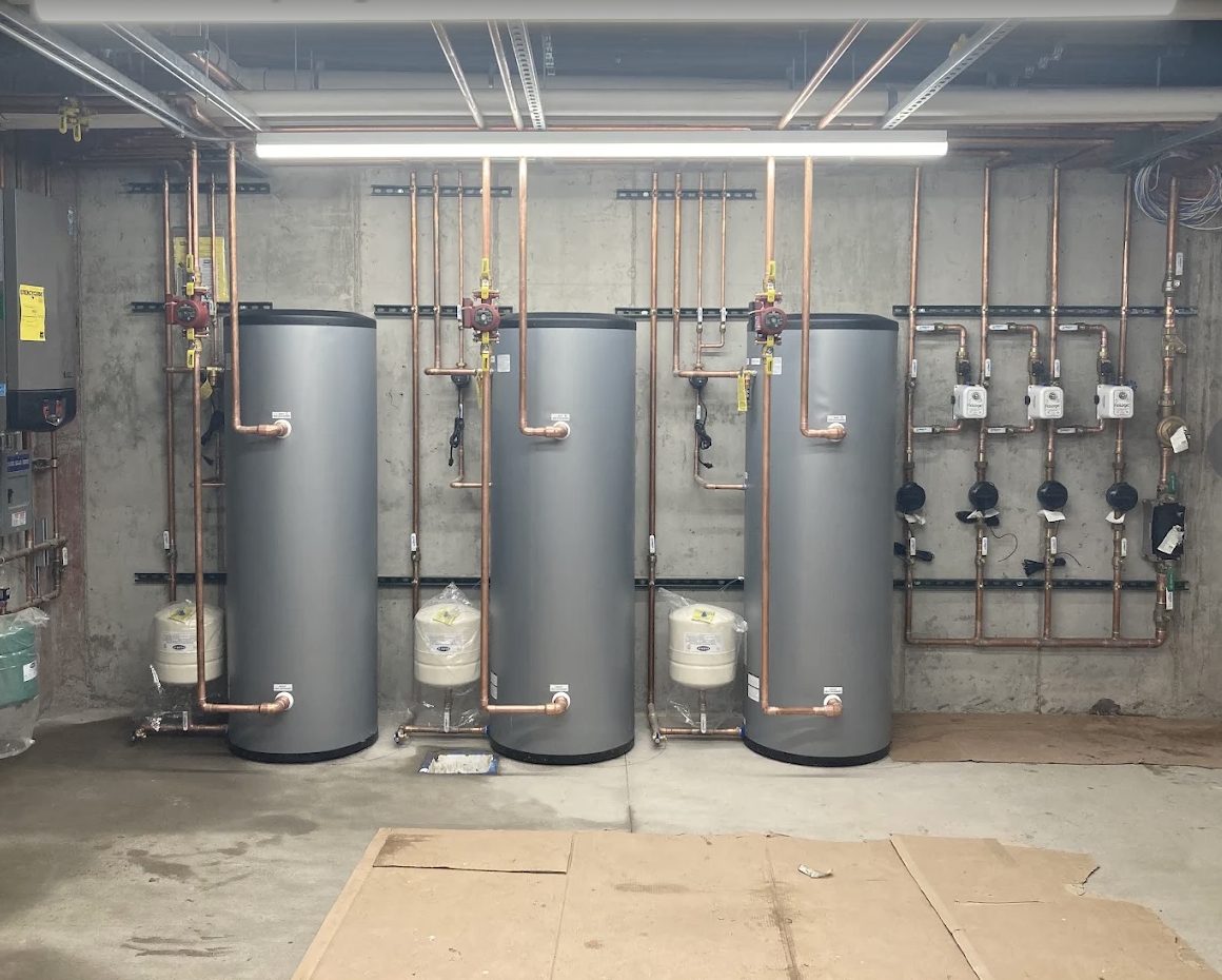 Three indirect water heater tanks installed side by side with neat copper piping by Top Tier